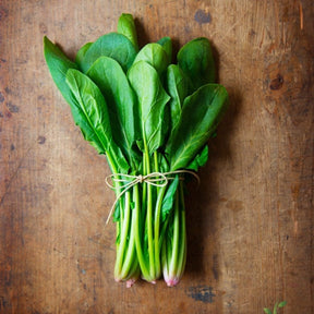 Fresh Bloomsdale spinach seeds by SeedsNow, showing vibrant green seed packets for planting spinach.